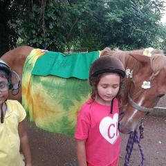 Two children petting chestnut horse